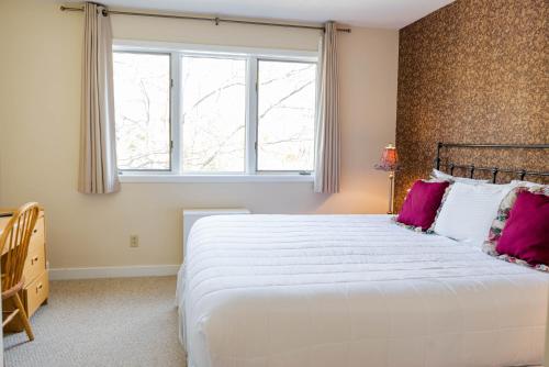 Stratton MountainVantage Point Villas at Stratton Mountain Resort的卧室配有带粉红色枕头的大型白色床