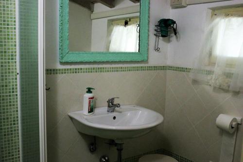 卡斯泰尔诺沃马格拉Fattoria Cristina Bilo Rosa的一间带水槽和镜子的浴室