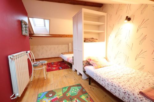 Mentièresla grange aux créations的一间小卧室,配有两张床和窗户