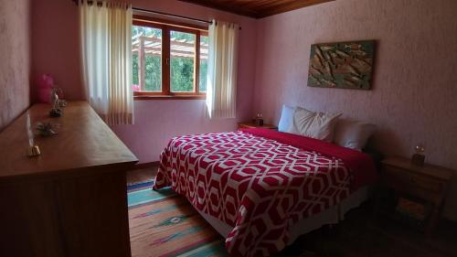 维奥康德马奥Sitio Shekinah的卧室设有红色和白色的床和窗户。