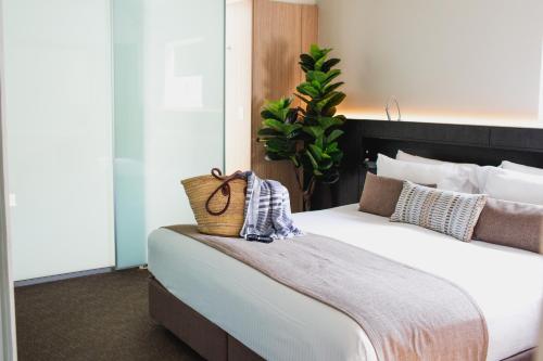 努萨角Seahaven Noosa Beachfront Resort的一间卧室配有一张大床,上面有篮子