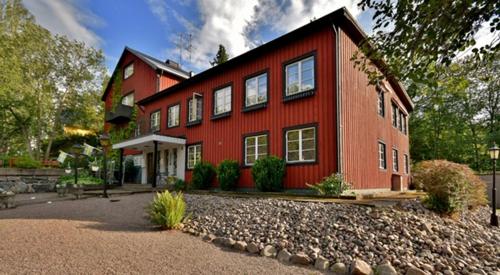 FågelforsFågelfors Wärdshus的前面有砂石车道的红色房子