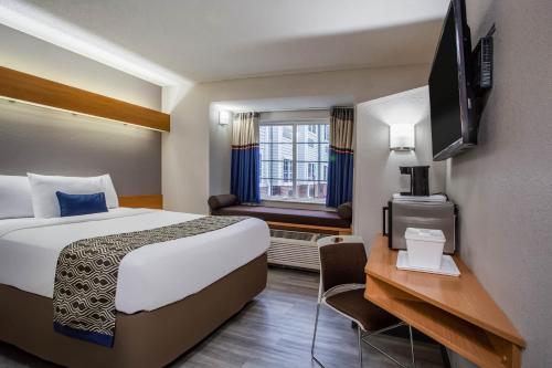 南派恩斯Microtel Inn & Suites by Wyndham Southern Pines Pinehurst的一间设有大床和窗户的酒店客房