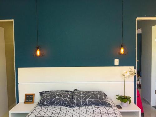 嘎林海斯港LINDO, NOVO, ÓTIMA LOCALIZAÇÃO的一张蓝色墙壁的床,上面有两盏灯