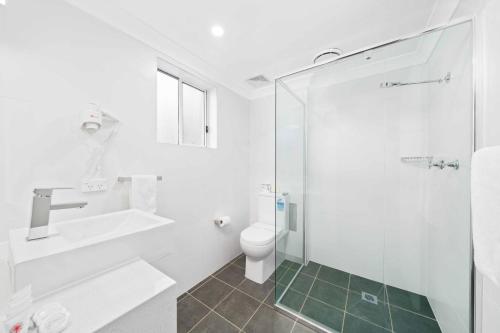 班克斯镇WM Bankstown的浴室配有卫生间、盥洗盆和淋浴。