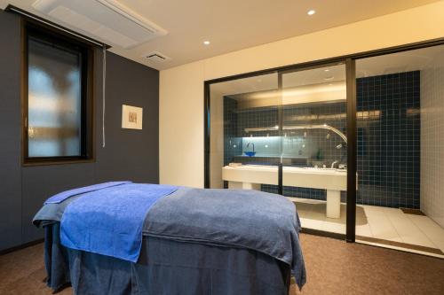 别府AMANE resort GAHAMA的一间卧室设有一张床、一个窗户和一间浴室
