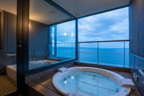 别府AMANE resort GAHAMA的带浴缸和大窗户的大浴室