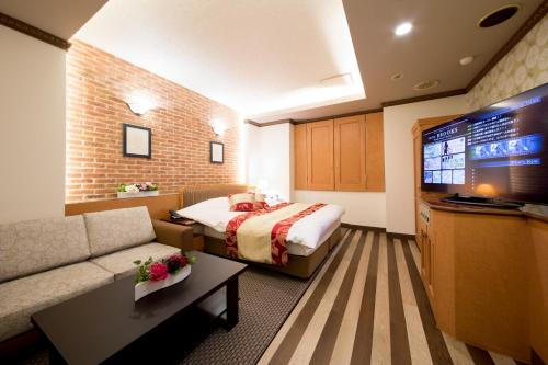 KasukabeHotel Brooks (Adult Only )的配有一张床和一台平面电视的酒店客房
