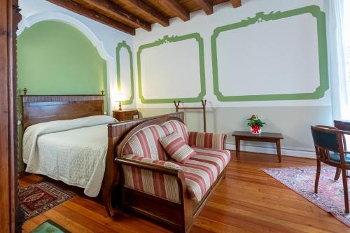 PolcenigoPalazzo Scolari的一间卧室配有一张床、一把椅子和窗户。