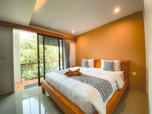 沙努尔Radha Homestay的一间卧室设有一张大床和大窗户