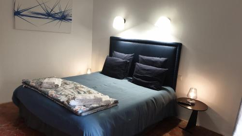 马诺斯克la bastide de l'adrech的一间卧室配有一张带蓝色床单和枕头的床。