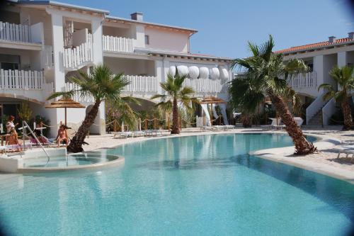 利多迪耶索罗Cala Blu Residence con piscina-Centralissimo Lido di Jesolo的棕榈树酒店前的游泳池
