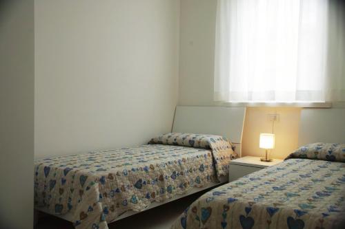 利多迪耶索罗Cala Blu Residence con piscina-Centralissimo Lido di Jesolo的小型客房 - 带2张床和窗户