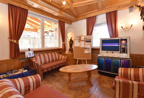 维哥迪法萨Al Piccolo Hotel的客厅配有电视、沙发和桌子