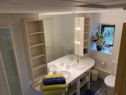 埃文河畔布拉德福Herb Cottage的白色的浴室设有两个盥洗盆和镜子