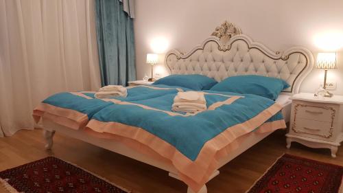 卢布尔雅那E&E Apartments 4* Arena Stožice的一间卧室配有一张大床,配有蓝色的床单和蓝色的枕头。