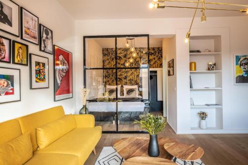 布鲁塞尔Mini loft 1 bedroom 2 steps from Av Louise的客厅配有黄色的沙发和床。