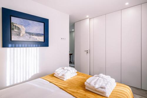 波尔图BBA Apartments Palácio I - Douro View & Parking的一间卧室配有一张床,上面有两条毛巾
