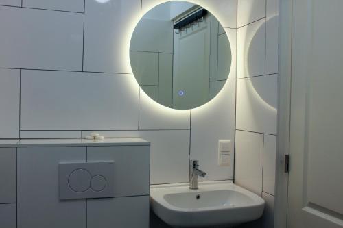 海牙Central Studios的白色的浴室设有水槽和镜子