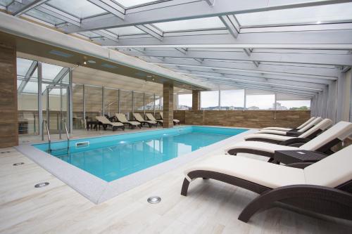 巴尼亚卢卡塔利亚酒店的一个带躺椅的游泳池和一个游泳池