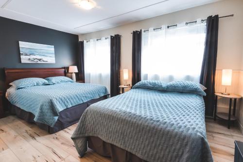 拉拜乐广场酒店的一间卧室设有两张床和窗户。