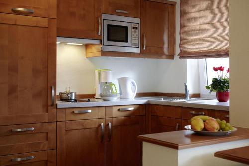 措布伦Alpenjuwel Rohnenspitze的厨房配有木制橱柜和一碗水果