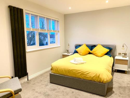 Bar Hill Stylish Cambridge Pad的一间卧室配有一张带黄色枕头的床和一扇窗户