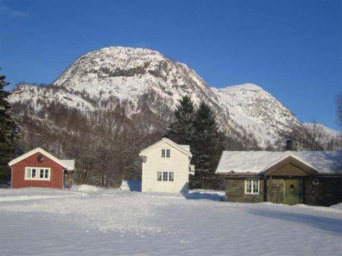 勒尔达尔Seim Camping - Røldal的一座雪覆盖的山,有两栋建筑和一栋房子