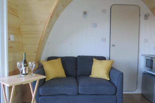 埃尔斯米尔Archers Meadow Shropshire的蓝色的沙发,配有黄色枕头和桌子