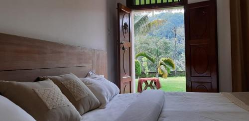 VandiperiyārCassells Jungle Resorts Thekkady的一间卧室设有床、窗户和门