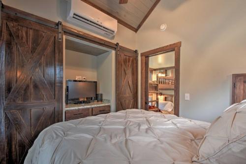 摩根顿Secluded Morganton Tiny Home with Hot Tub Access!的一间卧室设有一张大床和一个大木门
