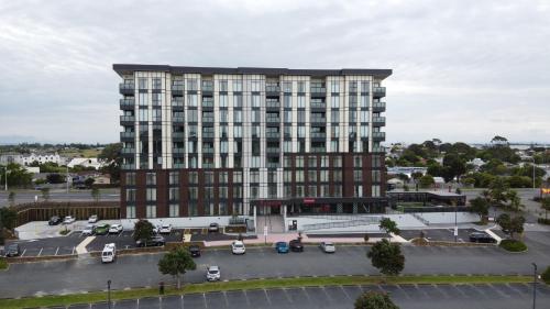 奥克兰Ramada Suites by Wyndham Manukau的一座大型建筑,前面设有停车场