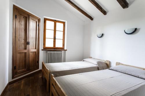 阿梅利亚Barca Country House的配有窗户和门的客房内的两张床