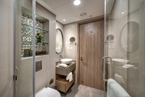 迪拜The S Hotel Al Barsha的浴室配有卫生间、盥洗盆和淋浴。