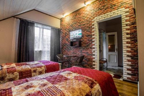 莫申Садиба Вікторія的一间卧室设有两张床和砖墙