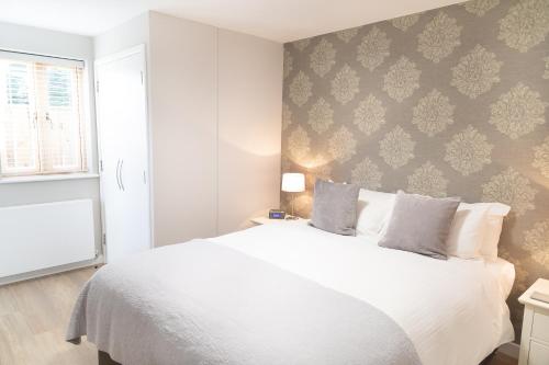 剑桥Citystay - Hinton House的卧室配有白色的床和墙壁