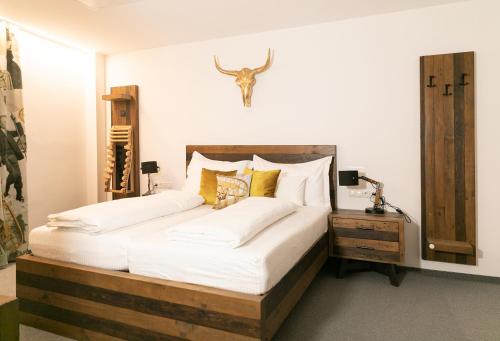 因斯布鲁克伊格尔斯运动酒店的卧室配有一张大床,墙上挂着鹿头