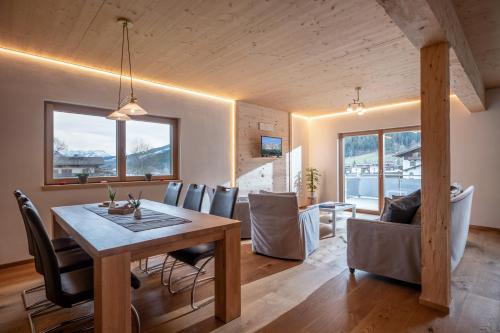 格英Alpenchalet "DAHOAM"的用餐室以及带桌椅的起居室。