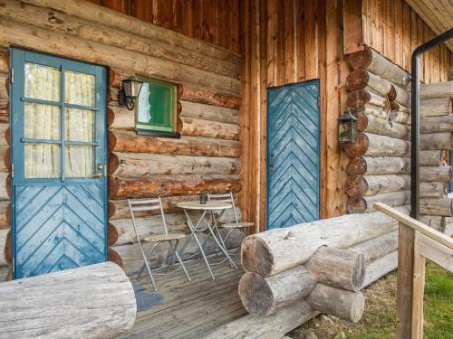拉赫登佩拉Holiday Home Vuokatinportti a 11 by Interhome的小木屋设有蓝色的门和桌子
