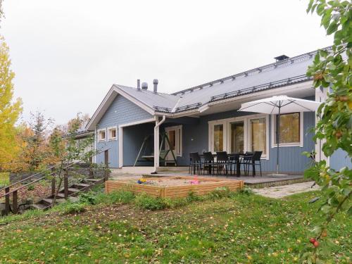 罗瓦涅米Holiday Home Villa lehmus by Interhome的蓝色的房子,配有桌椅和雨伞