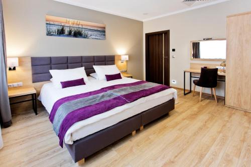克拉科夫Hotel CONRAD Comfort的一间卧室配有一张大床和一张书桌