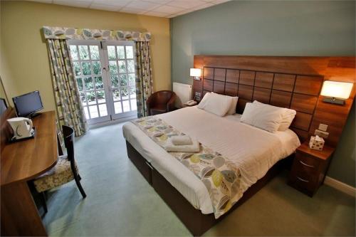 拉夫堡阔恩农庄酒店的一间卧室配有一张床、一张书桌和一个窗户。
