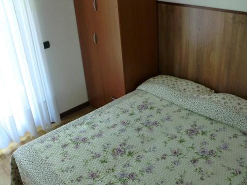 加尔达湖滨Villa Berta的小卧室配有一张带花卉床罩的床