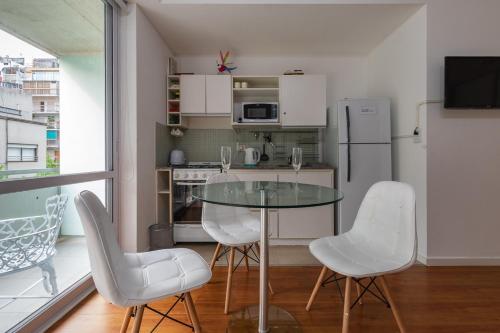 布宜诺斯艾利斯Estudio en lo mejor de Palermo * Estilo y glamour *的厨房配有玻璃桌和白色椅子