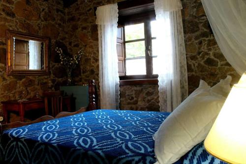 TiñorCASA MARY LOLA的一间卧室设有蓝色的床和窗户。