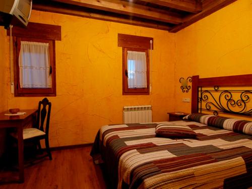 纳瓦莱诺La Casona del Herrero的卧室配有床、桌子和窗户。