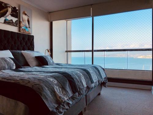 康康Hermoso departamento con increíble vista!的一间卧室设有一张床和一个大窗户