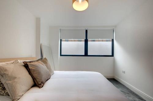 谢菲尔德Stylish Sheffield City Spot的窗户客房内的一张白色床