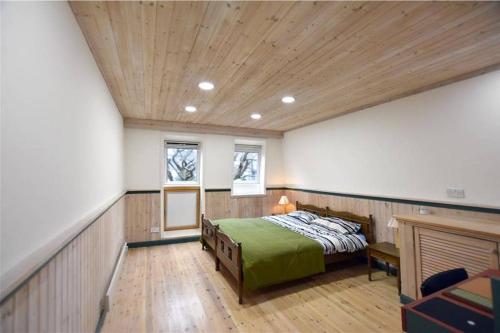 勒威克Unique, perfectly located town centre house的一间卧室设有一张床和木制天花板