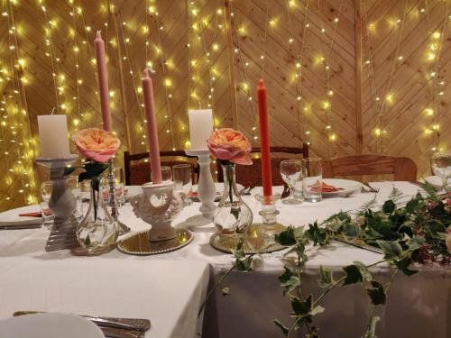 SpāreVeccepļi kempings的一张桌子,上面放着蜡烛和鲜花,房间里放着灯